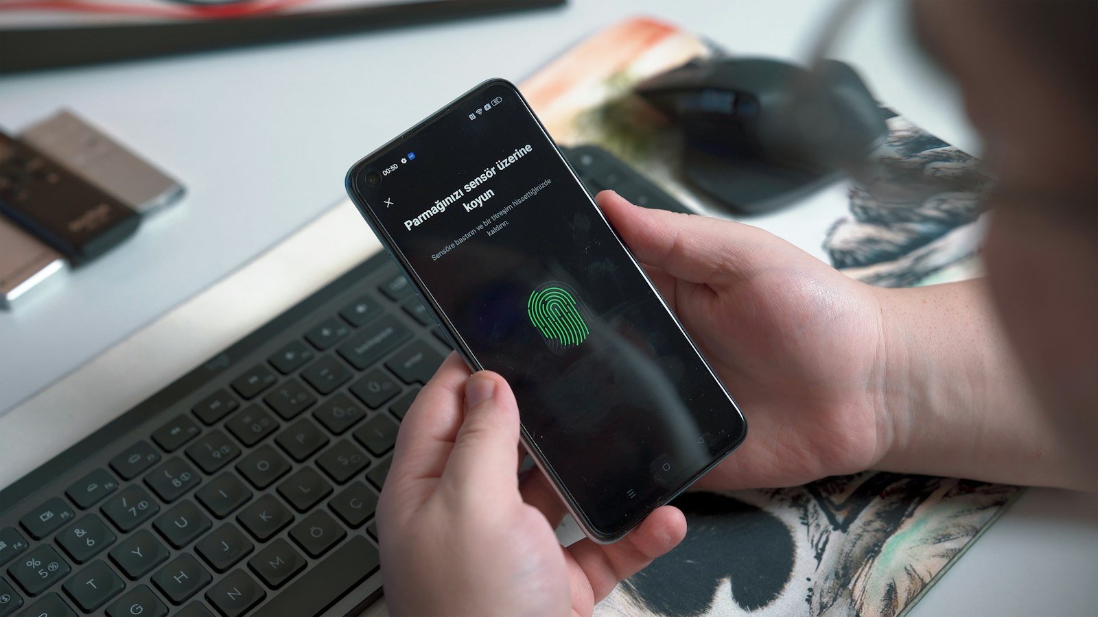 Person unlocking a smartphone with a fingerprint sensor, illustrating passkey sign-in