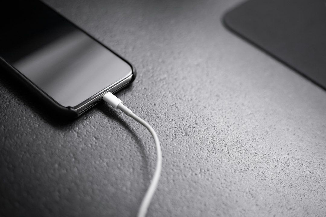 Black smartphone connected to a charger cable